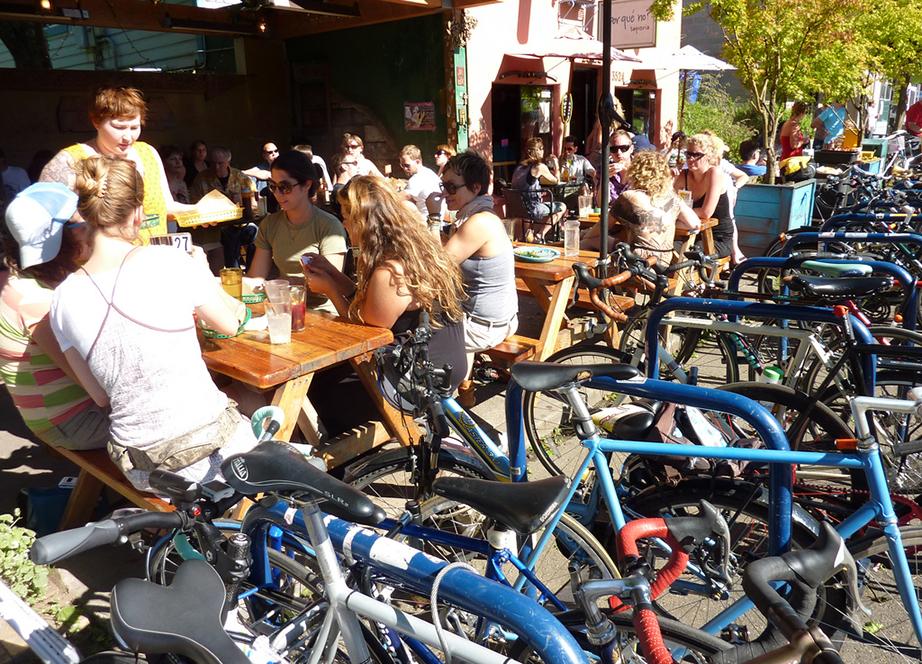 People eating at a restaurant with ample bicycle parking