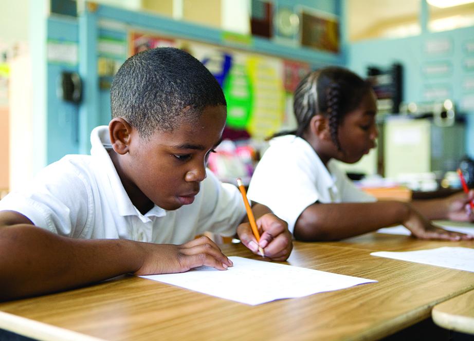 Children in a classroom writing on paper